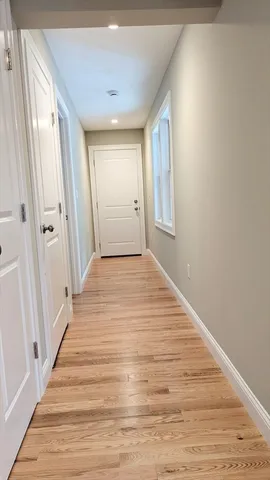 a view of a hallway with wooden floor