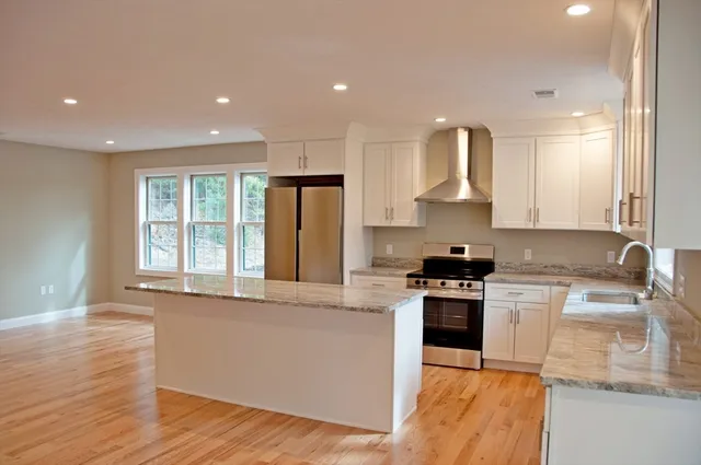 a kitchen with stainless steel appliances granite countertop a stove a sink and a refrigerator