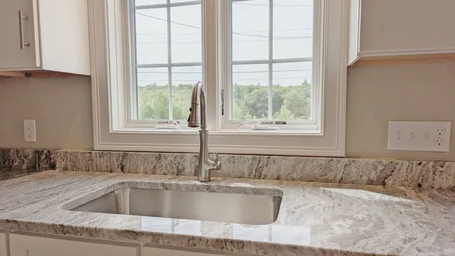 a view closed with a granite countertop sink and mirror