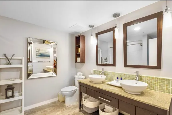 a bathroom with a granite countertop toilet sink and mirror
