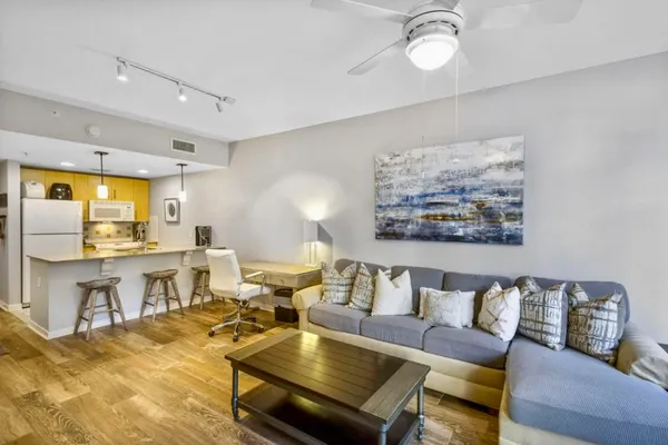 a living room with furniture and view of kitchen