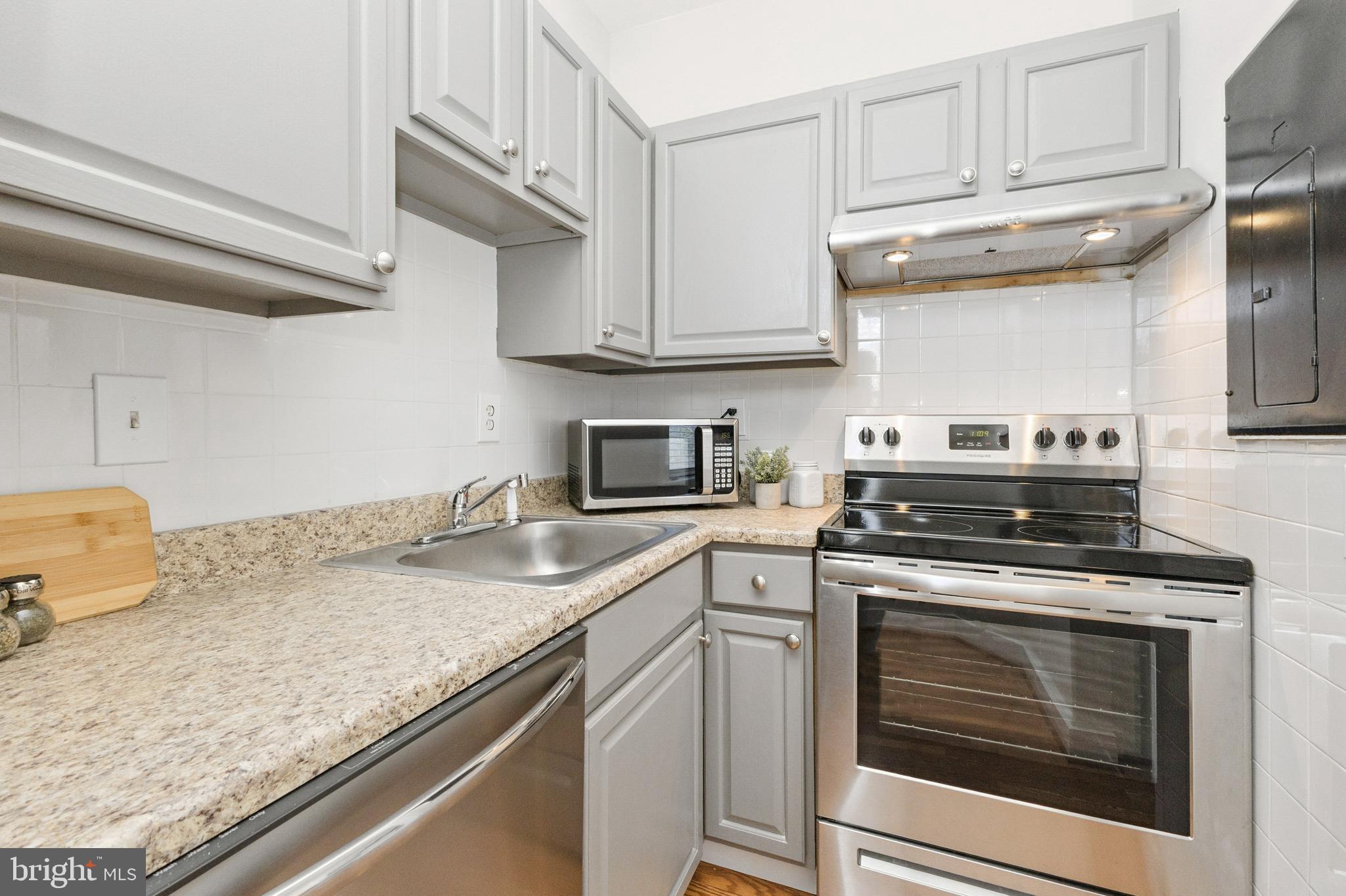 7 18th Street Southeast, Unit 208 Washington, DC 20003 - Photo 8 of 32 a kitchen with granite countertop cabinets stainless steel appliances and a counter space