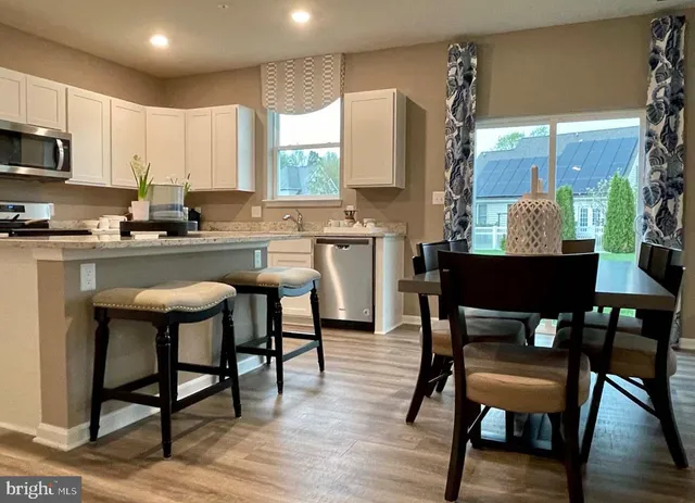 a kitchen with a table chairs refrigerator and cabinets