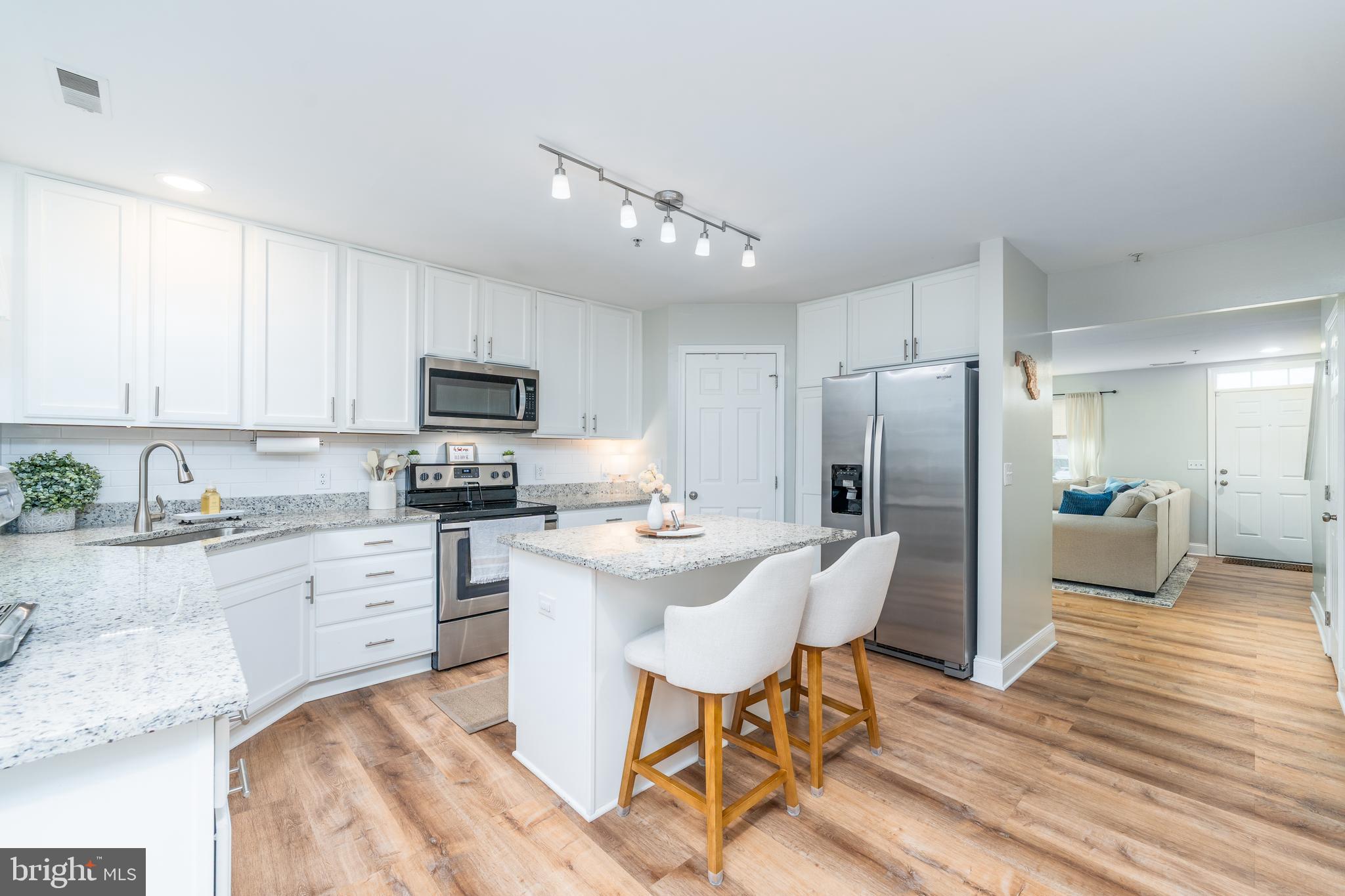 688 Luthardt Road Baltimore, MD 21220 - Photo 1 of 32 a kitchen with stainless steel appliances granite countertop a refrigerator a stove top oven a sink dishwasher and white cabinets with wooden floor