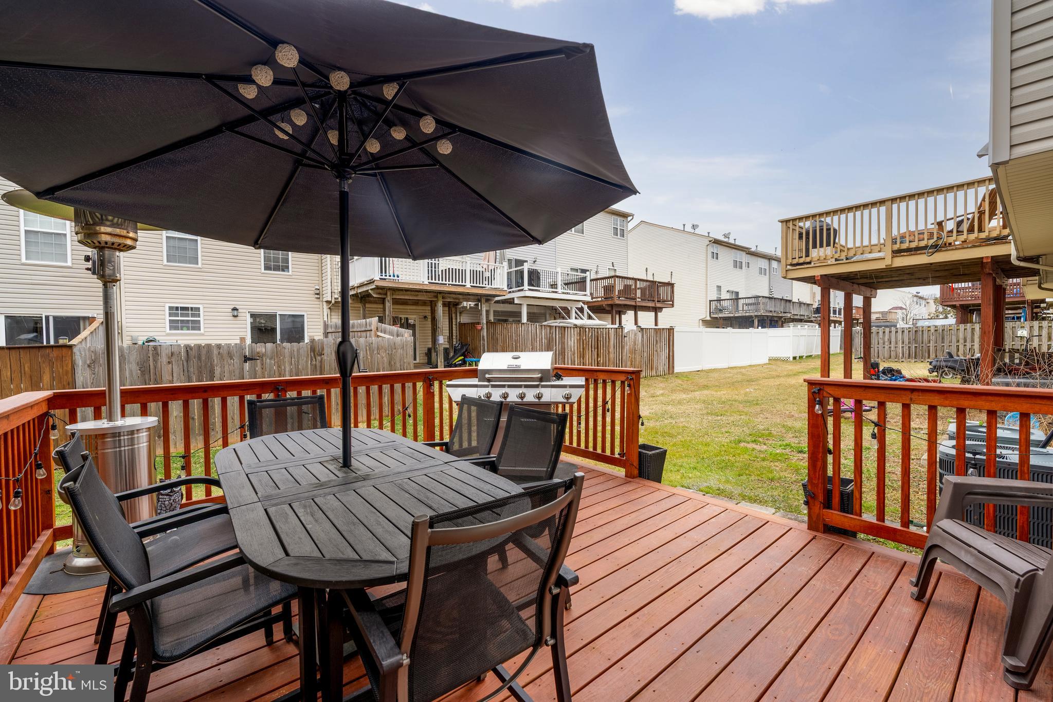 688 Luthardt Road Baltimore, MD 21220 - Photo 13 of 32 a view of a balcony with table and chairs under an umbrella with wooden floor