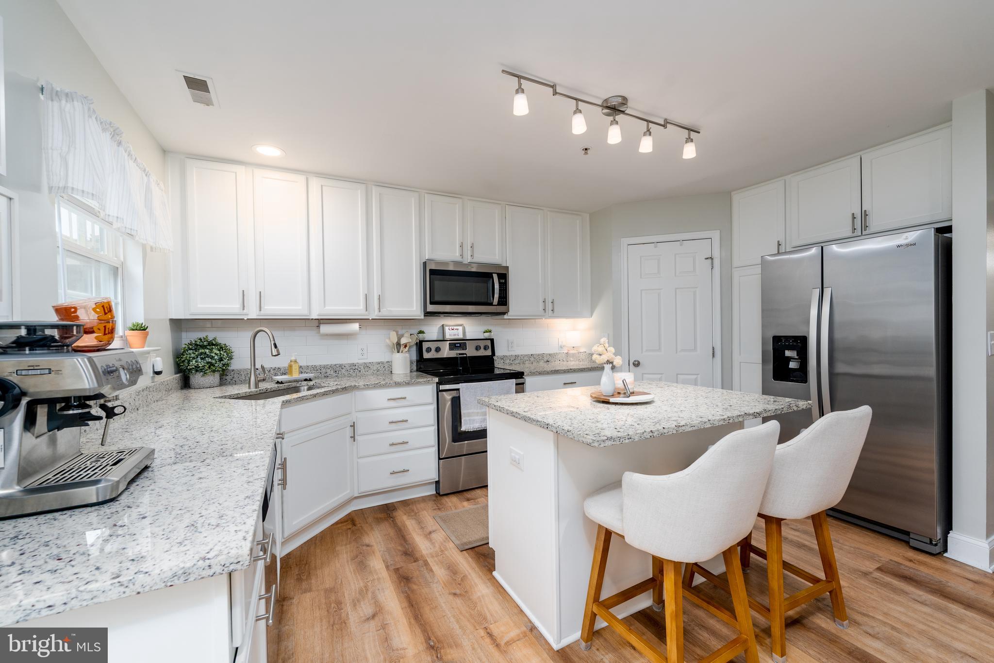 688 Luthardt Road Baltimore, MD 21220 - Photo 6 of 32 a kitchen with a sink a stove a refrigerator and white cabinets with wooden floor