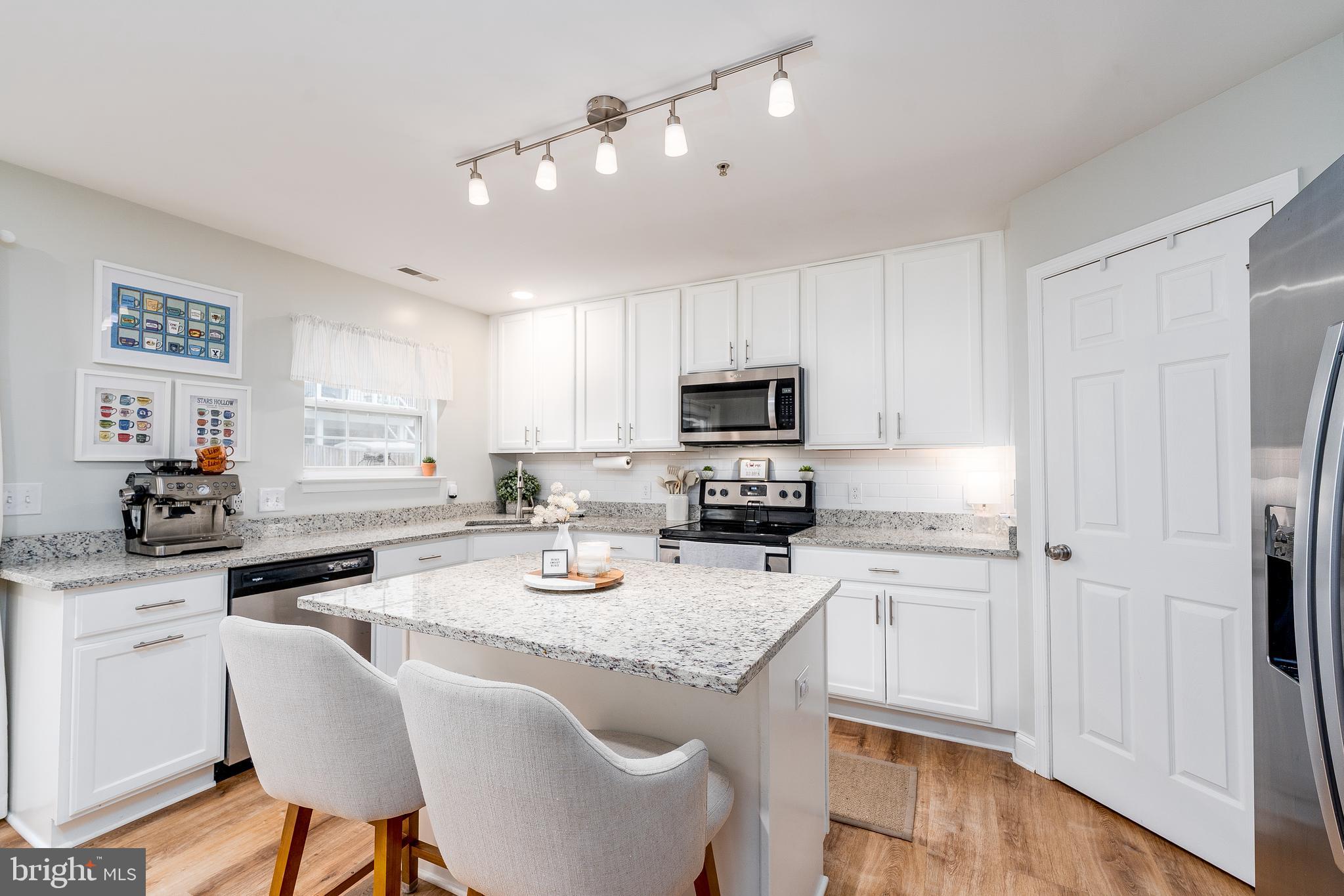 688 Luthardt Road Baltimore, MD 21220 - Photo 8 of 32 a kitchen with stainless steel appliances granite countertop a refrigerator a stove a sink dishwasher and white cabinets with wooden floor