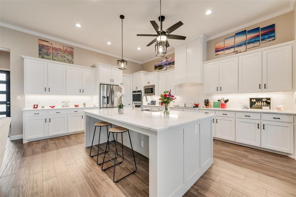 4041 Richard Road Midlothian, TX 76065 - Photo 31 of 36 a kitchen with stainless steel appliances kitchen island granite countertop a sink cabinets and wooden floor