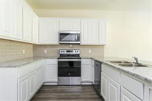 690 Union Street, Unit 2 Bonham, TX 75418 - Photo 4 of 12 a kitchen with stainless steel appliances granite countertop a sink stove and microwave