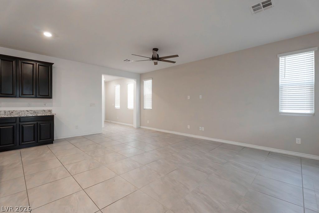 7126 Calvert Cliffs Street North Las Vegas, NV 89084 - Photo 5 of 44 A spacious, open concept living area boasts a modern ceiling fan and sleek tile flooring.