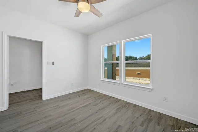 an empty room with a window and a fan