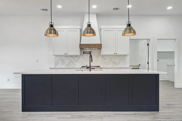 a kitchen with kitchen island granite countertop a sink stainless steel appliances and cabinets