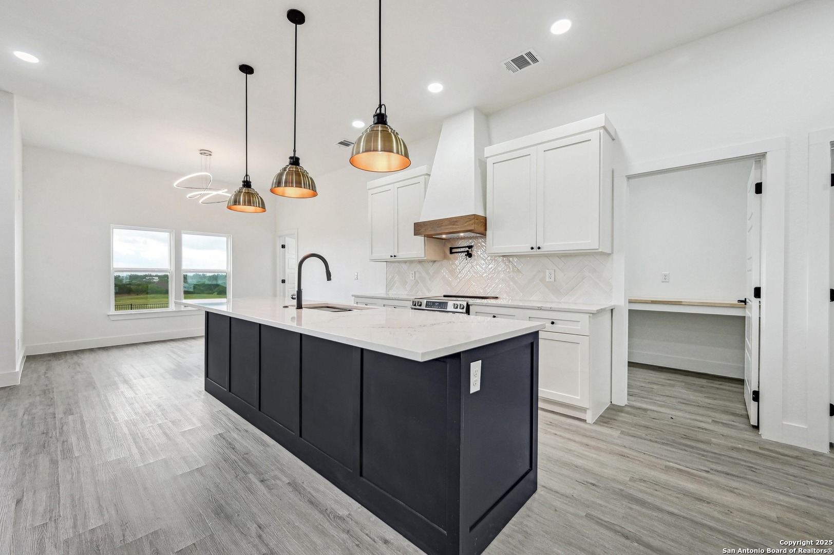236 Peter Kleid Loop Blanco, TX 78606 - Photo 5 of 21 a kitchen with kitchen island a sink a stove and a wooden floor