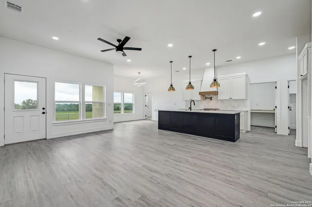 a large kitchen with stainless steel appliances kitchen island a large counter top and a wooden floors