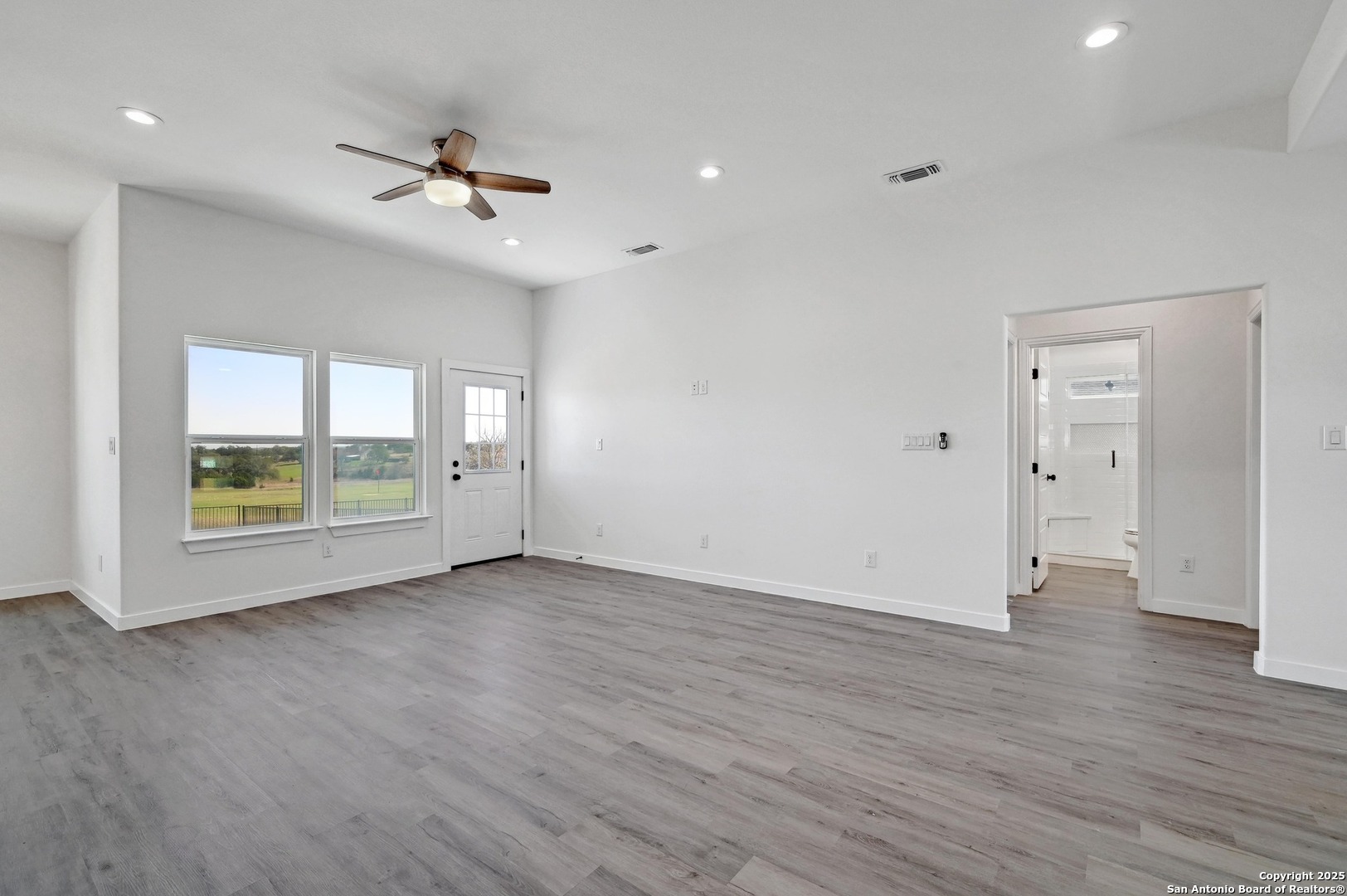 236 Peter Kleid Loop Blanco, TX 78606 - Photo 9 of 21 a view of an empty room with a window and wooden floor