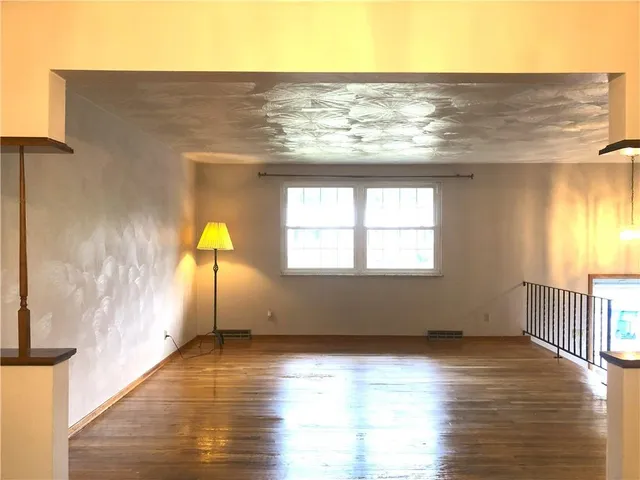 a view of a livingroom with wooden floor and a window