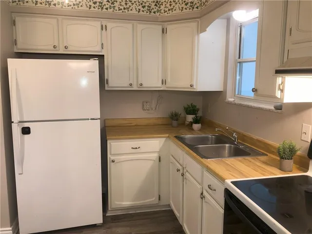 a kitchen with a refrigerator sink and cabinets