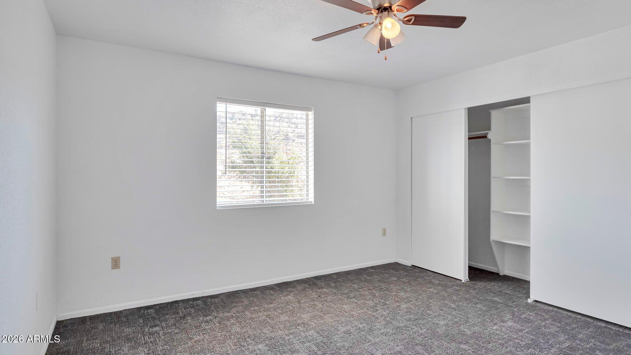 4125 North Pima Way Rimrock, AZ 86335 - Photo 11 of 14 an empty room with chandelier fan and windows