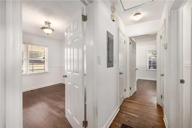 a view of a hallway with wooden floor and a chandelier