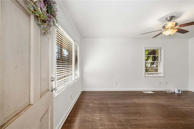 a view of empty room with window and chandelier fan