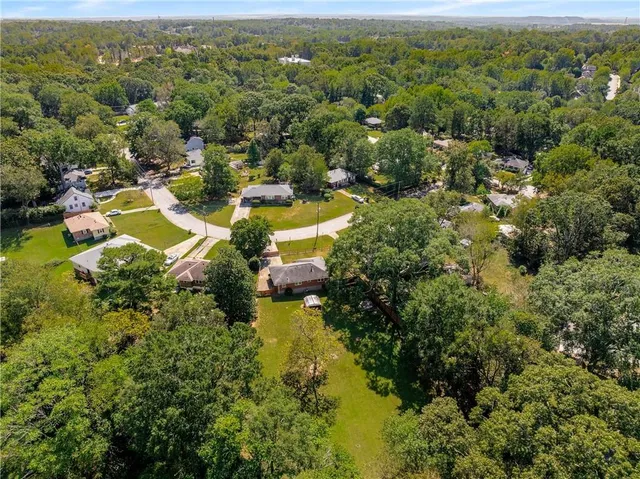 an aerial view of residential houses with outdoor space and trees