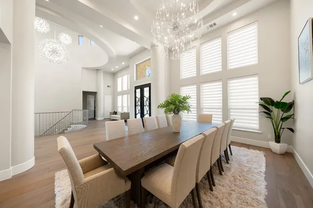 a kitchen with stainless steel appliances kitchen island granite countertop a stove a sink a refrigerator and a dining table with wooden floor