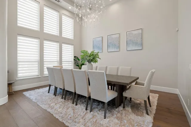 a kitchen with stainless steel appliances kitchen island granite countertop a dining table chairs refrigerator and microwave