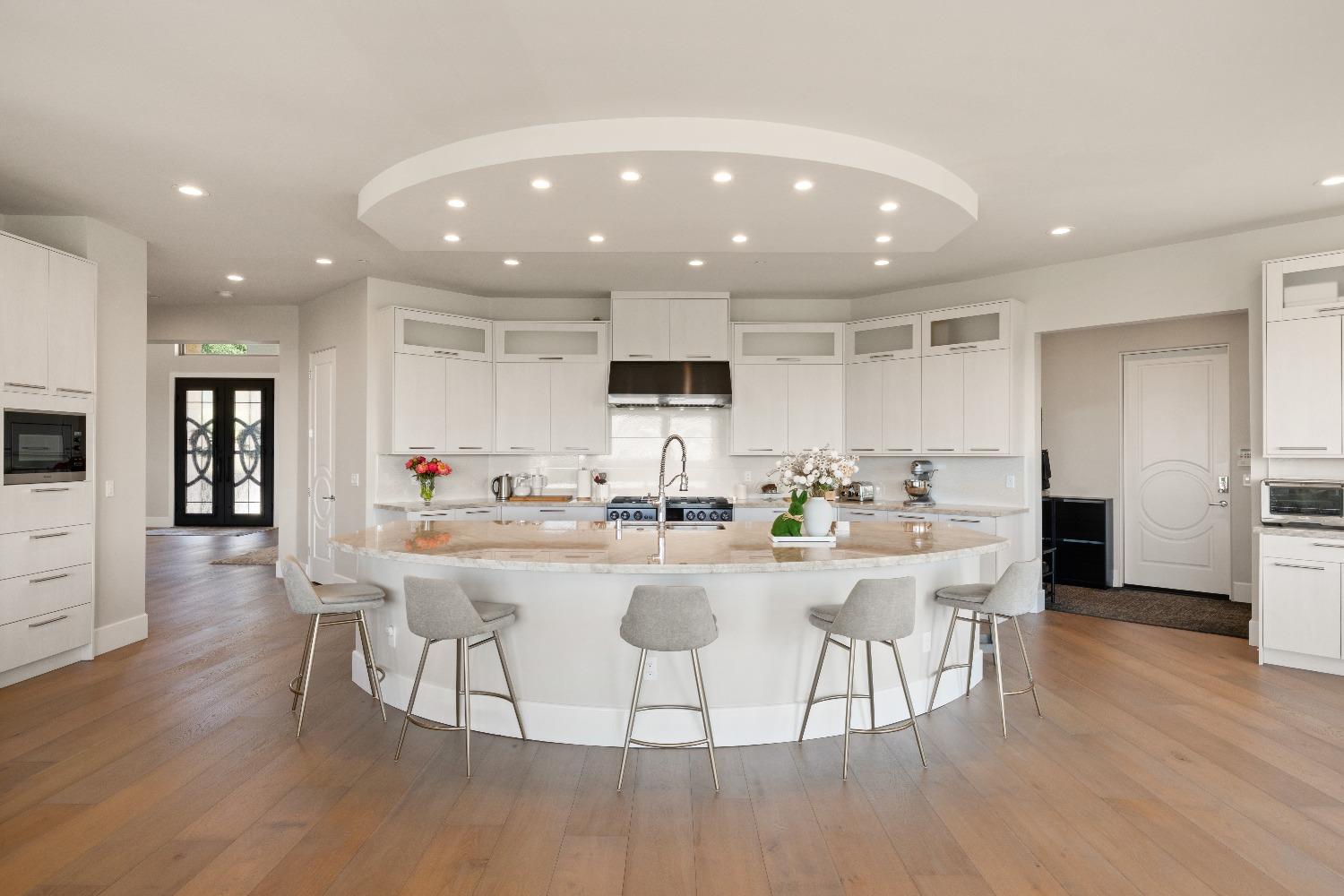 4023 Cornwall Court Rocklin, CA 95677 - Photo 18 of 85 a kitchen with stainless steel appliances kitchen island granite countertop a stove a sink a refrigerator and a dining table with wooden floor