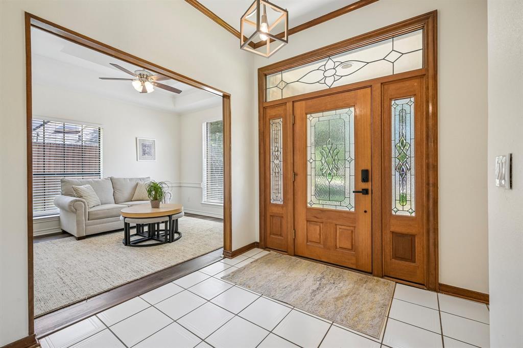 925 Spring Brook Drive Allen, TX 75002 - Photo 3 of 30 Welcoming foyer featuring solid wood entry doors with decorative glass panels, sidelights, and transom window detailing