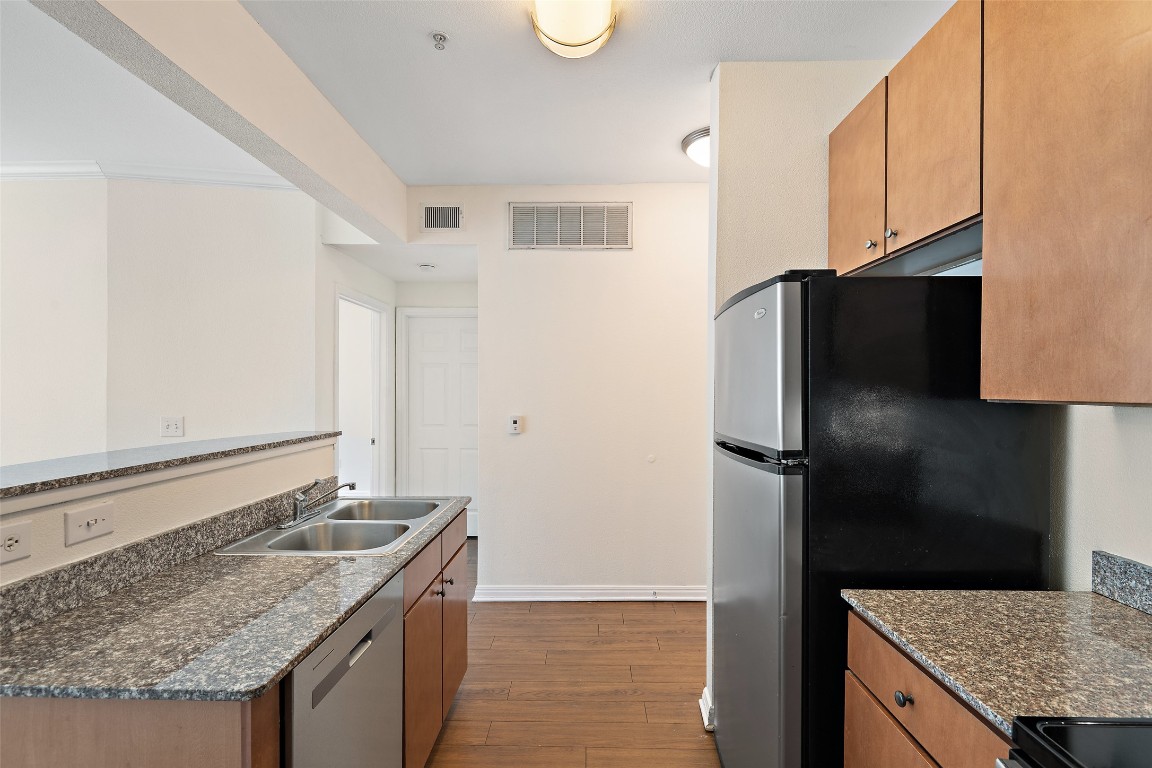 2502 Leon Street, Unit 417 Austin, TX 78705 - Photo 4 of 30 a kitchen with a granite counter top and refrigerator