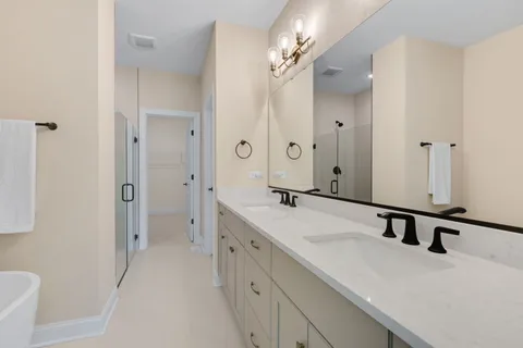 a bathroom with a double vanity sink a mirror and a shower