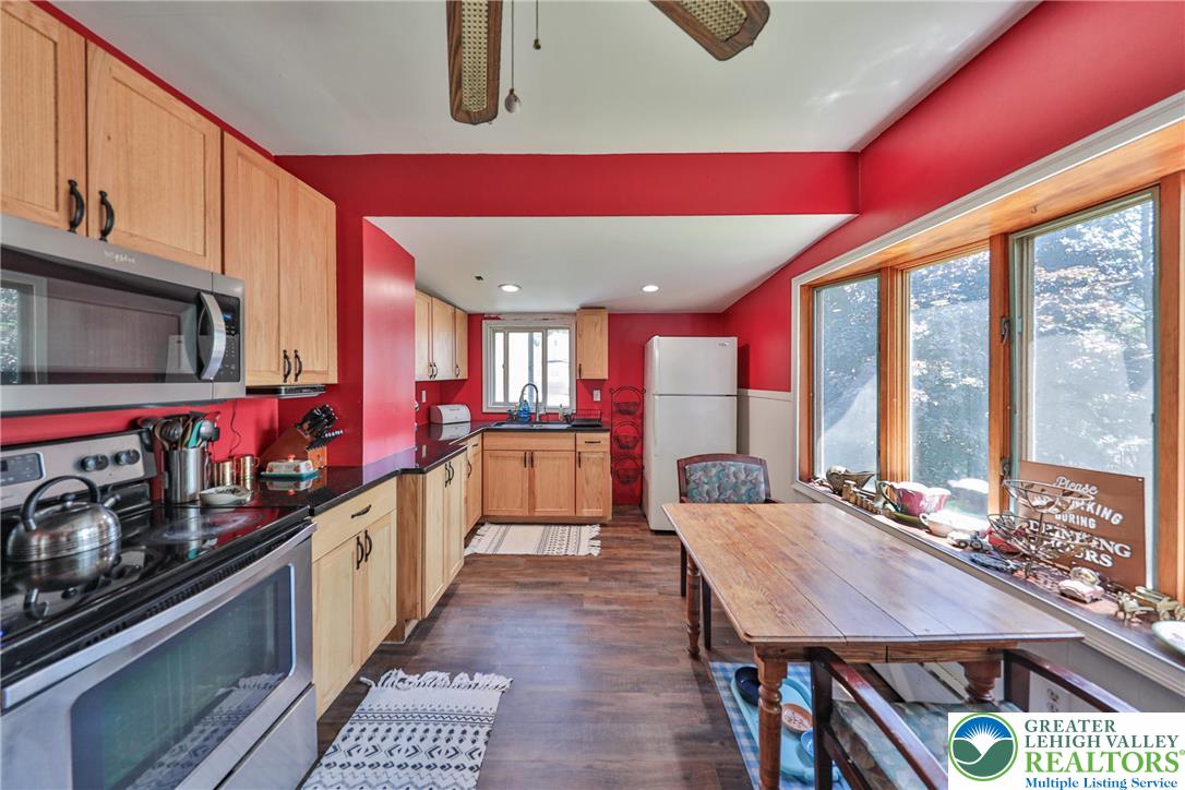 417 3rd Street Lehighton, PA 18235 - Photo 3 of 39 A well-equipped kitchen features a functional layout, warm wood cabinetry, and ample natural light from the large windows.