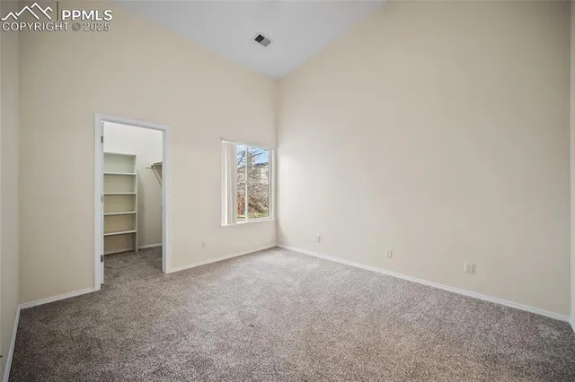 an empty room with windows and closet
