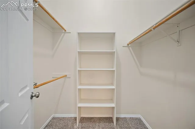 a view of walk in closet with empty racks