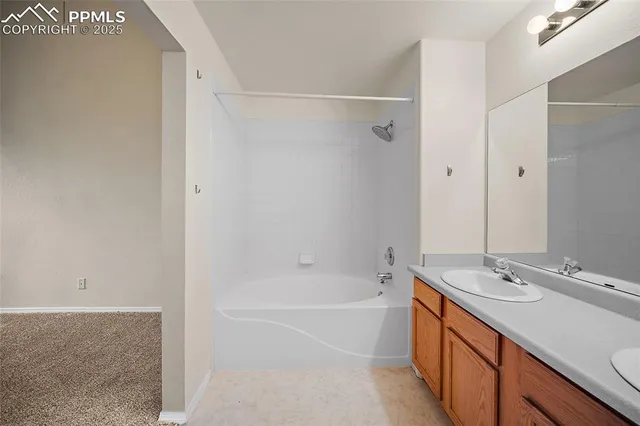 a bathroom with a tub sink vanity granite and a shower
