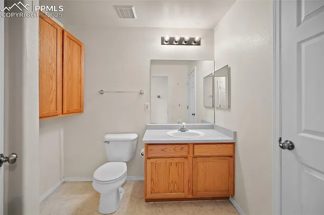 a bathroom with a granite countertop sink a toilet and a mirror
