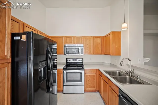 a kitchen with stainless steel appliances a refrigerator sink and stove