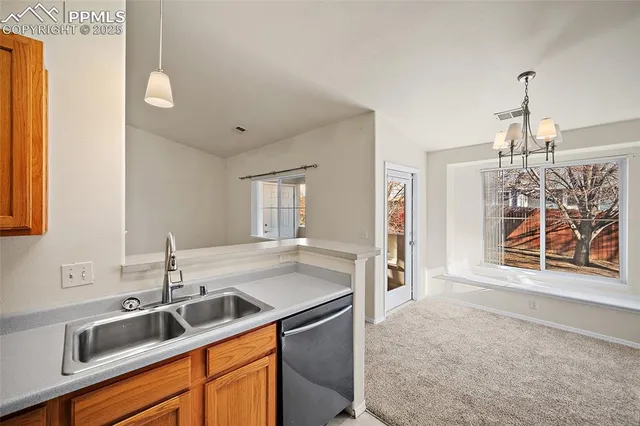 a kitchen with stainless steel appliances granite countertop a sink and a refrigerator