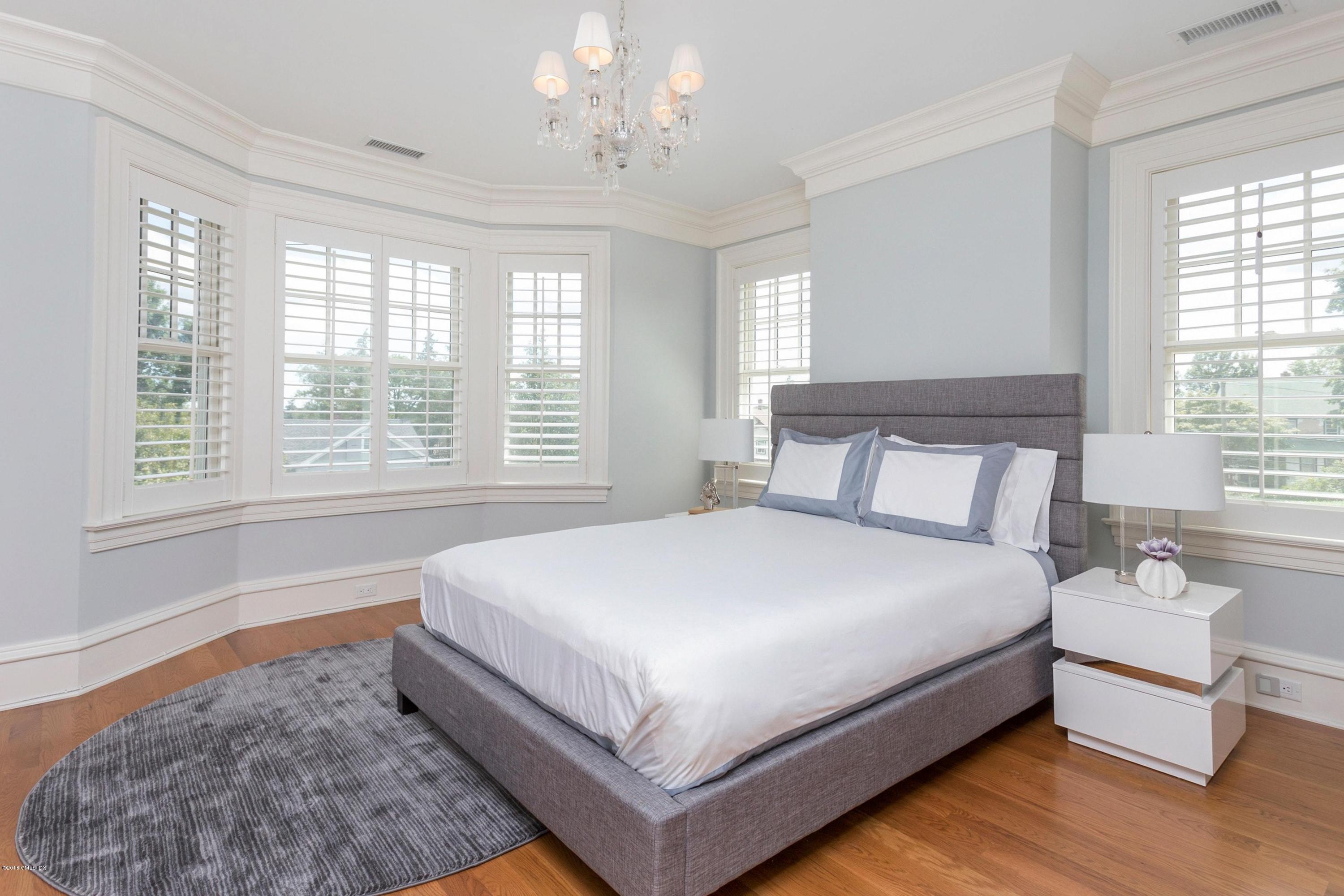 58 Ridge Street Greenwich, CT 06830 - Photo 19 of 29 a large bed sitting in a bedroom next to a window