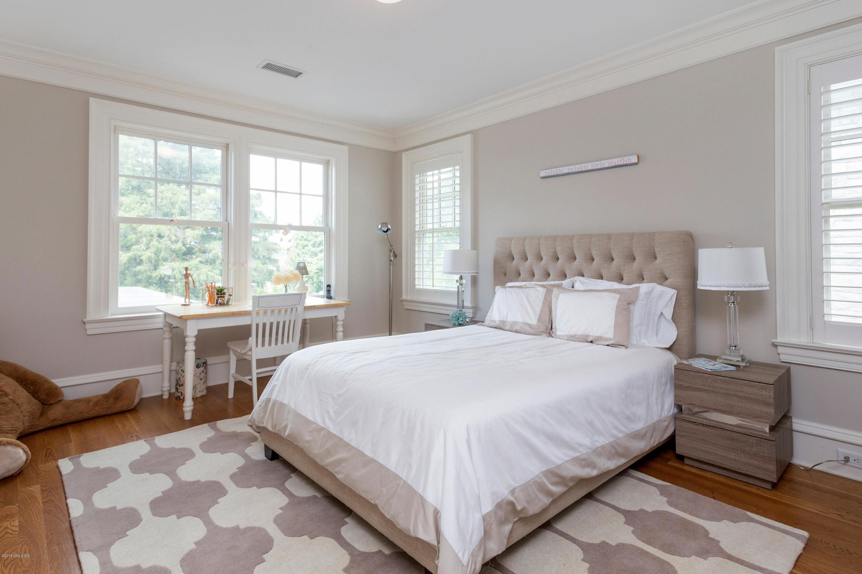 58 Ridge Street Greenwich, CT 06830 - Photo 20 of 29 a bedroom with a bed and a table chair