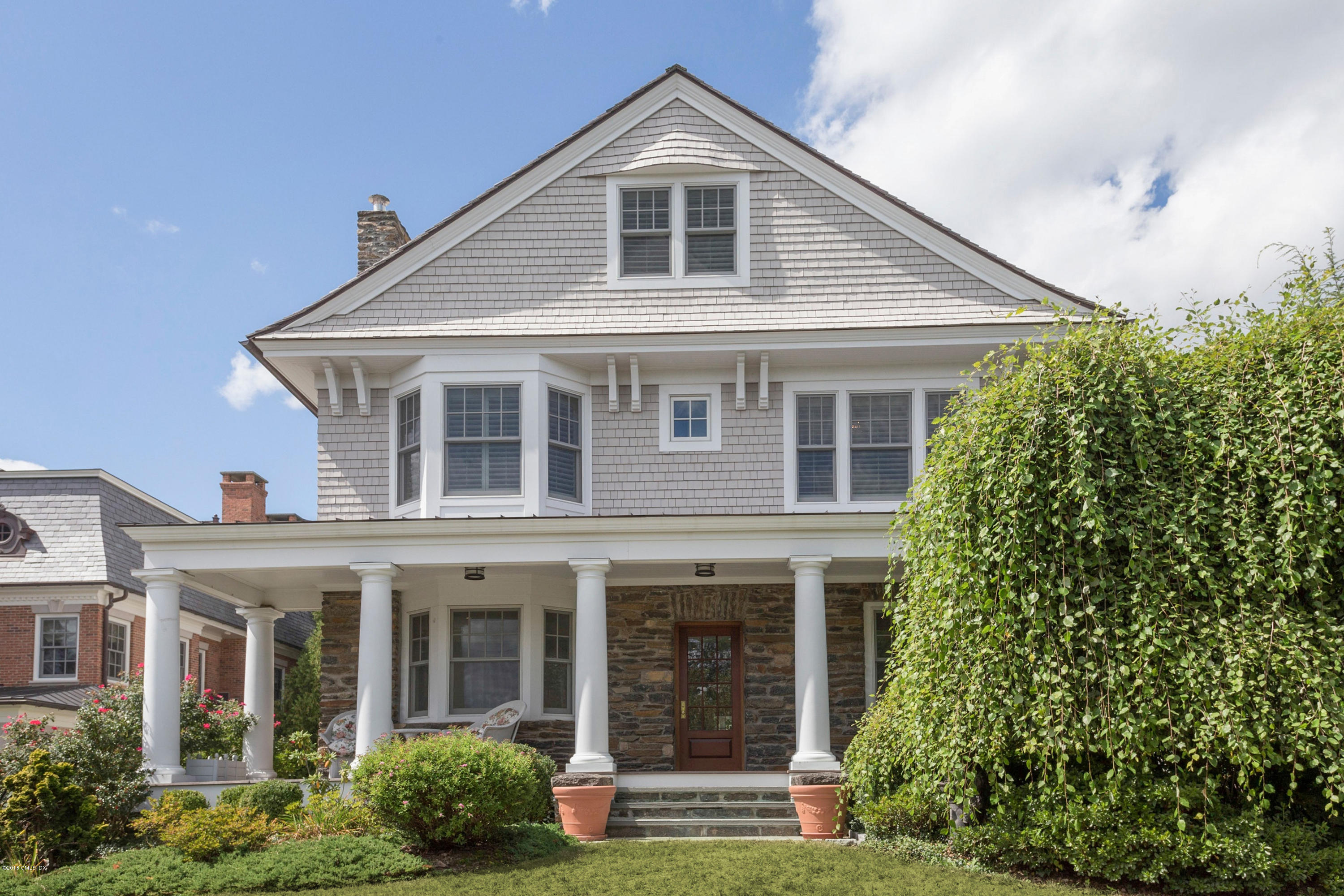 58 Ridge Street Greenwich, CT 06830 - Photo 2 of 29 a front view of a house with a yard and potted plants