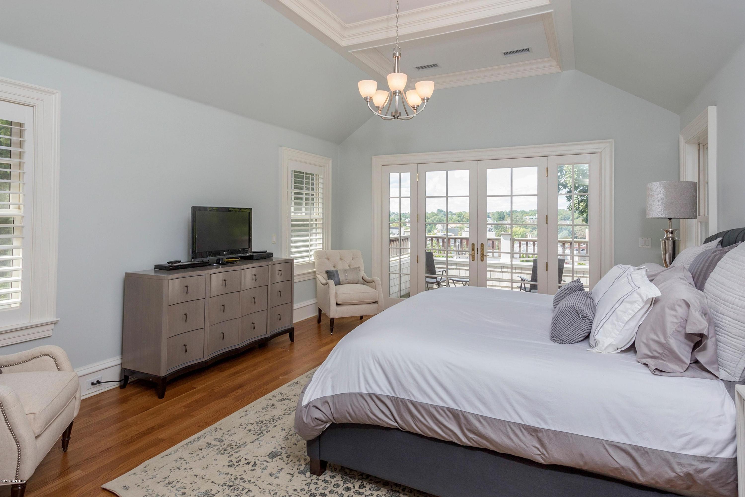 58 Ridge Street Greenwich, CT 06830 - Photo 22 of 29 a bedroom with a bed and a flat tv screen on dresser