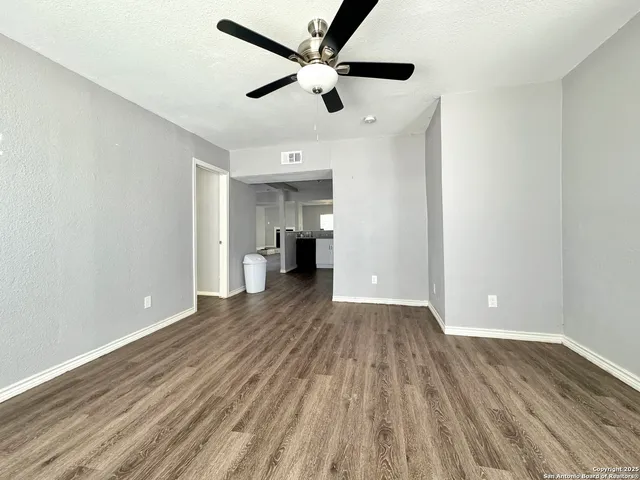 a view of empty room with wooden floor