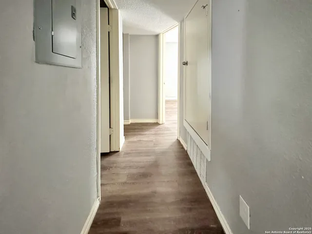 a view of a hallway with wooden floor