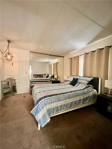 a large bed sitting in a room next to a lamp with a kitchen island