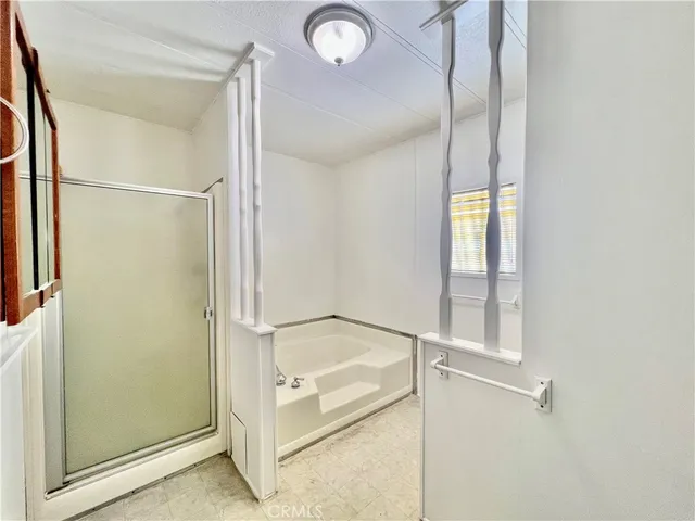 a bathroom with a glass shower door and a window