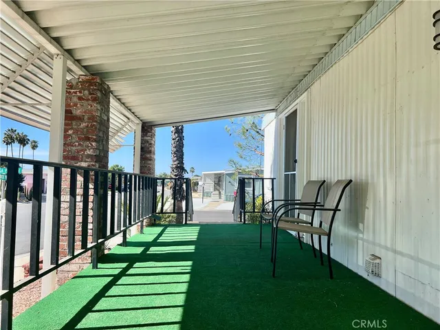 a view of a patio with table and chairs with wooden floor and fence