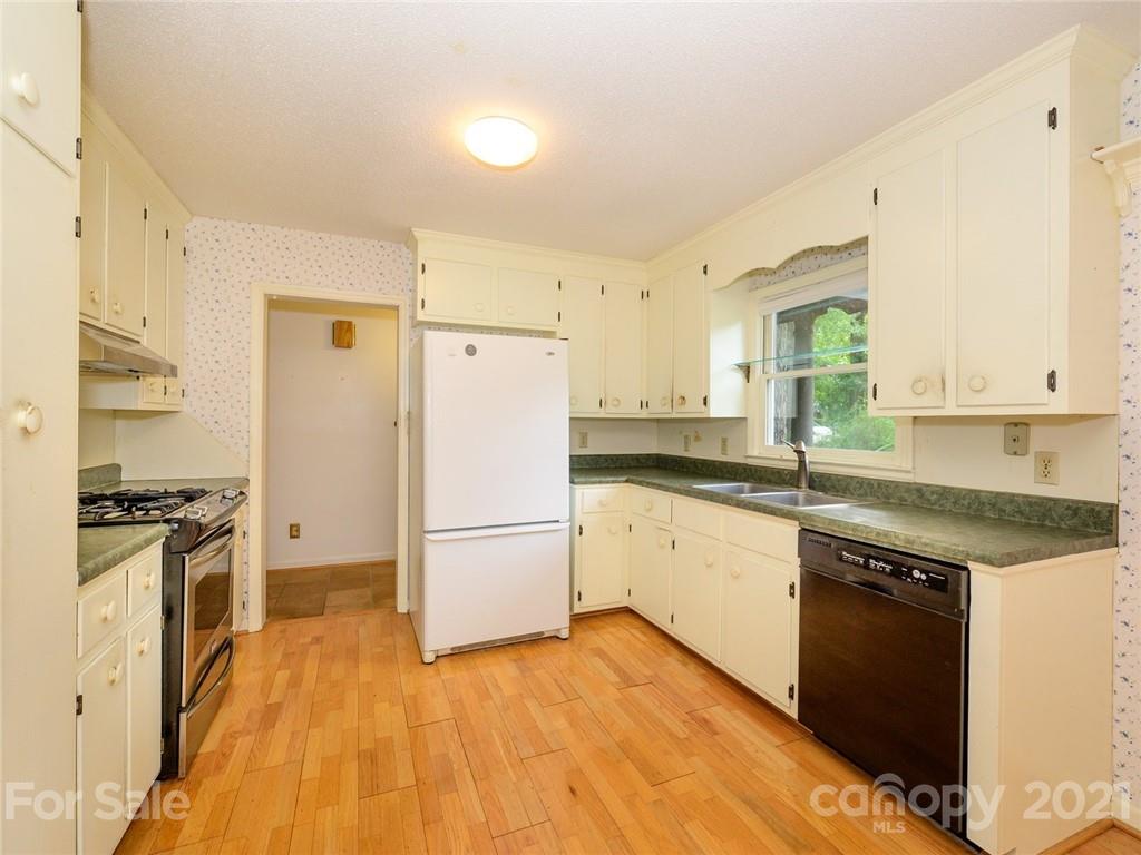 857 Pinebranch Road Rock Hill, SC 29730 - Photo 13 of 30 a kitchen with granite countertop a refrigerator a stove and white cabinets with wooden floor
