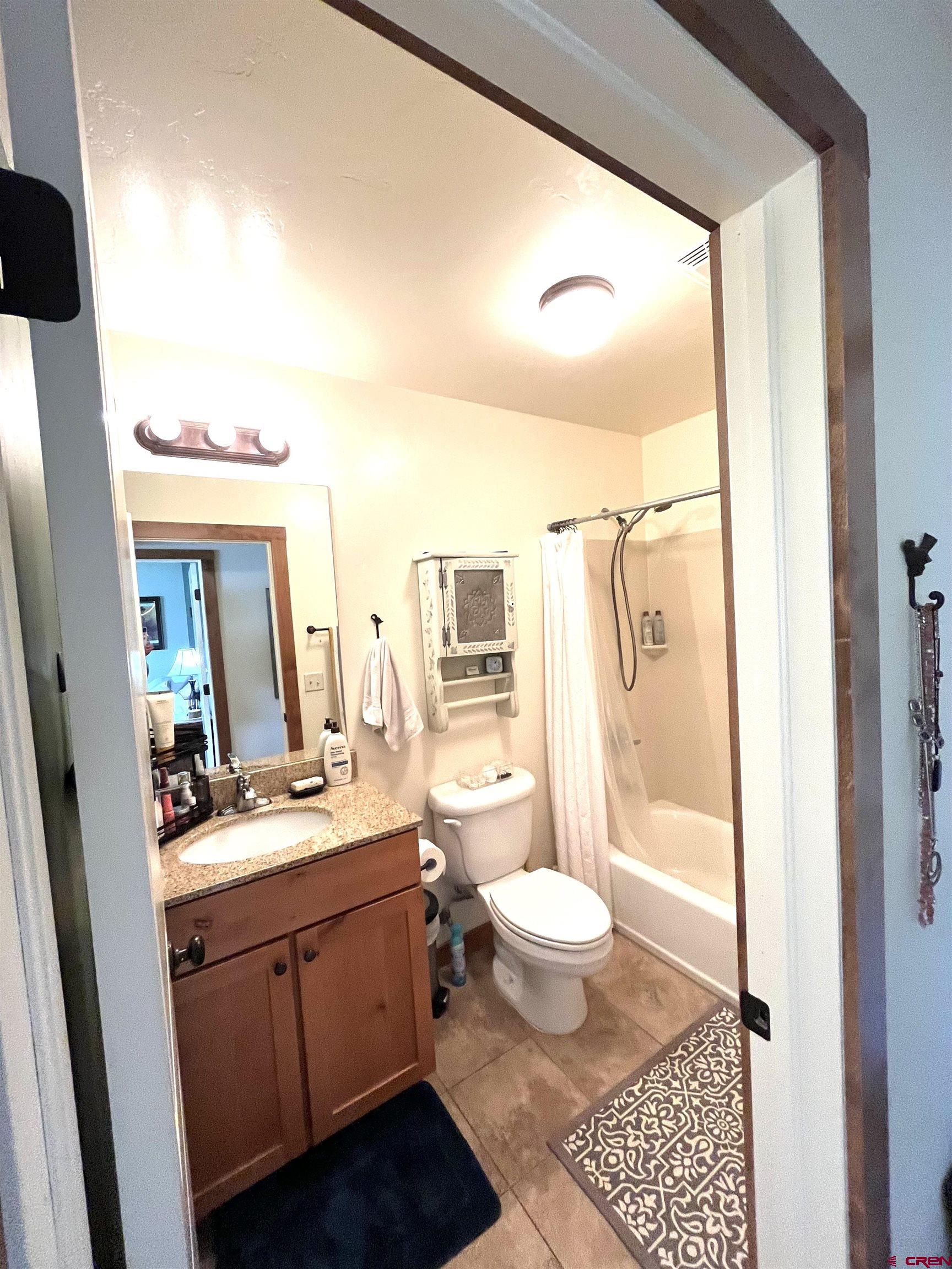 540 Redcliff Circle, Unit E104 Ridgway, CO 81432 - Photo 11 of 13 a bathroom with a sink a toilet a mirror and shower