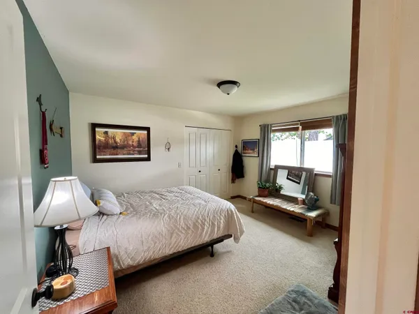 a bedroom with a bed and a dresser with wooden floor